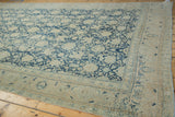 Faded denim blue and antique ivory Safavid palmettes on a distressed vintage Tabriz rug border.