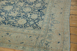 Corner detail of distressed vintage Tabriz with denim blue Safavid palmettes and intact selvage.