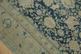 Distressed denim blue field with Safavid palmette and vine motifs meeting beige border.