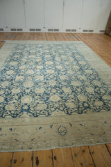 Distressed ivory-beige border of the vintage Tabriz carpet, showing faded denim blue motifs.