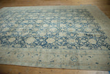 Distressed vintage Tabriz carpet corner, featuring denim blue lattice and patterned border.