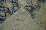 Folded vintage distressed Tabriz carpet corner, showing denim blue Safavid lattice pile and beige reverse.