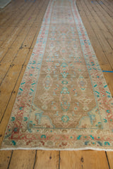 Angled view of a vintage distressed Hamadan runner showing its full length and soft, earthy patina.
