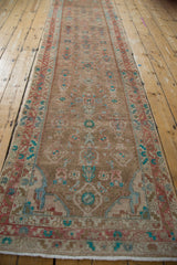 Angled view of a distressed Hamadan runner highlighting its long form and allover Herati design.