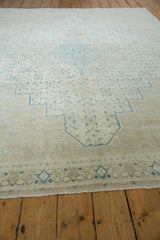 Low-angle view of the distressed Persian rug, emphasizing its low pile and geometric pattern.
