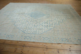 Angled perspective of a distressed Birjand carpet highlighting its low pile and muted blue medallion.
