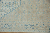 Distressed texture of a vintage Birjand carpet with soft sky blue and sand geometric motifs.