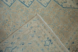 The hand-knotted foundation and distressed, sandy-toned pile of the vintage Birjand rug.