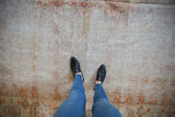 Vintage Amritsar square carpet's worn pile, showing exposed foundation and faded Herati design.