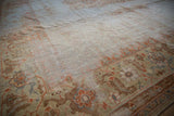 Angled detail of vintage Amritsar rug border, worn terra cotta samovar leaf motif.