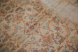Vintage Amritsar rug's worn Herati pattern in beige, terra cotta, and blue with visible foundation.