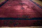 Art Deco carpet close-up: dusty raspberry red field with indigo border and floral sprays.