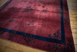 Vintage Nichols Art Deco carpet corner with dusty raspberry field, indigo border, and floral sprays.
