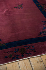 Dusty raspberry Art Deco carpet corner with indigo border, floral sprays, and original cotton selvage.