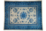 Antique Chinese Ningxia rug featuring blue phoenix, dragon, and bat motifs on beige.