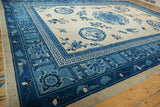 Antique Ningxia carpet corner: beige field, cobalt blue flying bat and lotus cloud borders.