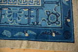 Antique Ningxia carpet corner with geometric border, sky blue field, lotus, and flying bat motifs.