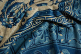 Folded pile showing geometric key and cloud band motifs in varying blues and beige.