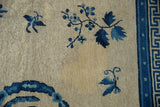Antique Ningxia carpet detail showing beige pile with blue botanical motifs and geometric minor border.