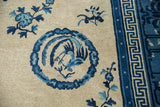 Antique Ningxia carpet detail: blue phoenix roundel, geometric meander border, beige field.