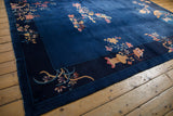 Dark indigo border of the Art Deco carpet featuring raspberry and copper floral vines.