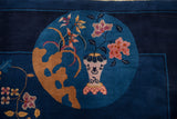 Art Deco rug detail: Pink lotus flowers in vase on teal blue ground.