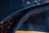Rich indigo blue pile with blooming raspberry and gold floral vine on Art Deco carpet.