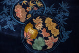 Carved Art Deco roundel medallions with gold, blush, and jade floral motifs on navy blue.