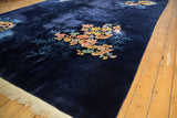 Navy blue Art Deco rug corner with floral medallion, bamboo, and fringe.