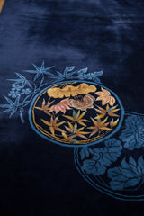 Art Deco carpet's roundel medallion with gold lotus, blush leaves, and navy ground.