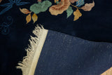 Vintage Nichols Art Deco carpet: deep navy floral pile, natural fringe, and tight woven foundation.