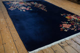 Oversized floral sprays in multiple colors on deep cobalt blue Art Deco rug.