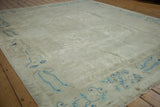 Textured ivory field of antique distressed Peking carpet with powder blue border design.