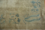 Beige distressed antique Peking carpet with powder blue vines and stylized peacock feather motifs.
