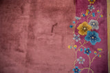 Art Deco vintage rug detail: pale raspberry border with saffron yellow, sky blue floral sprays and dusty mauve field.