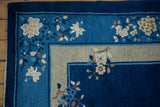Vintage Peking rug corner with cobalt blue field, raised beige floral sprays, and double border.
