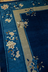 Vintage Chinese Peking rug's cobalt blue abrashed field with a floral sky blue and beige border.