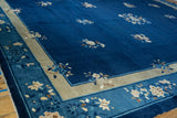 Vintage Chinese Peking rug corner with beige border and blue, ivory floral sprays.