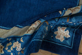 Curled section of vintage Peking carpet with cobalt blue pile and beige floral motif.