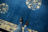 Antique Chinese Peking rug's indigo blue field with ivory border displaying Taoist motifs.