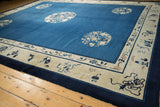 Antique Peking carpet with indigo blue field, ivory curvilinear medallion, and symbolic beige border.