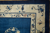 Antique Peking carpet corner: indigo field, ivory border with stylized blossoms, cloud band vinery.