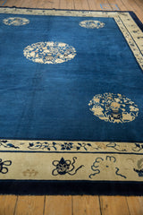 Antique Peking carpet's ivory border, detailed with dark blue stylized Taoist motifs.