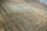 Distressed vintage Oushak rug showing muted dusty rose, ivory quatrefoil florals and vines.
