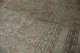 Distressed pile of vintage Oushak carpet with dusty rose quatrefoil motifs, charcoal geometric border.