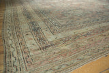 Distressed vintage Oushak rug corner showing worn pile texture, dusty rose and ivory borders.