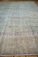 Textured pile of a distressed Sivas rug showcasing seafoam green and violet floral palmettes.