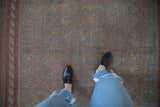 Distressed Afshar carpet close-up, showing faded ocean blue and terracotta germinating shrub pattern.