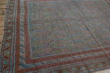 Distressed Afshar rug corner showing multi-band border, serrated leaves, and even wear in blue, chestnut, terracotta.