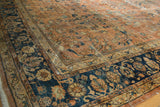 Mahal carpet's ornate floral vinery on dusty terracotta, with time-softened navy blue border.